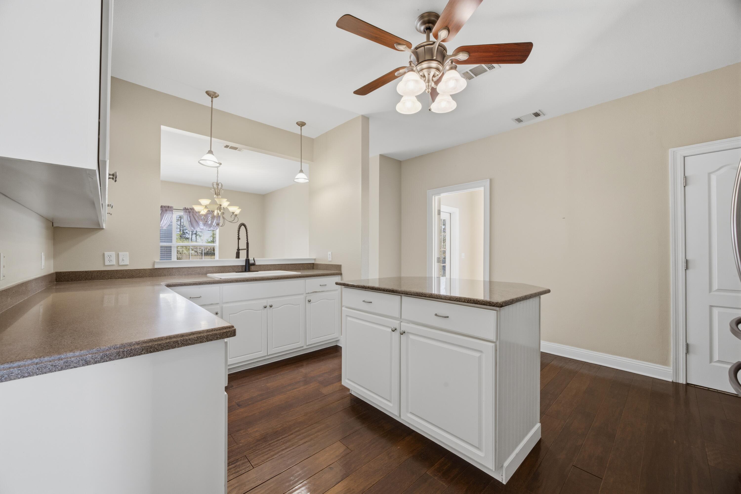 51 Tournament Lane Freeport, FL 32439 - Photo 27 of 71 a kitchen with granite countertop a sink cabinets and wooden floor