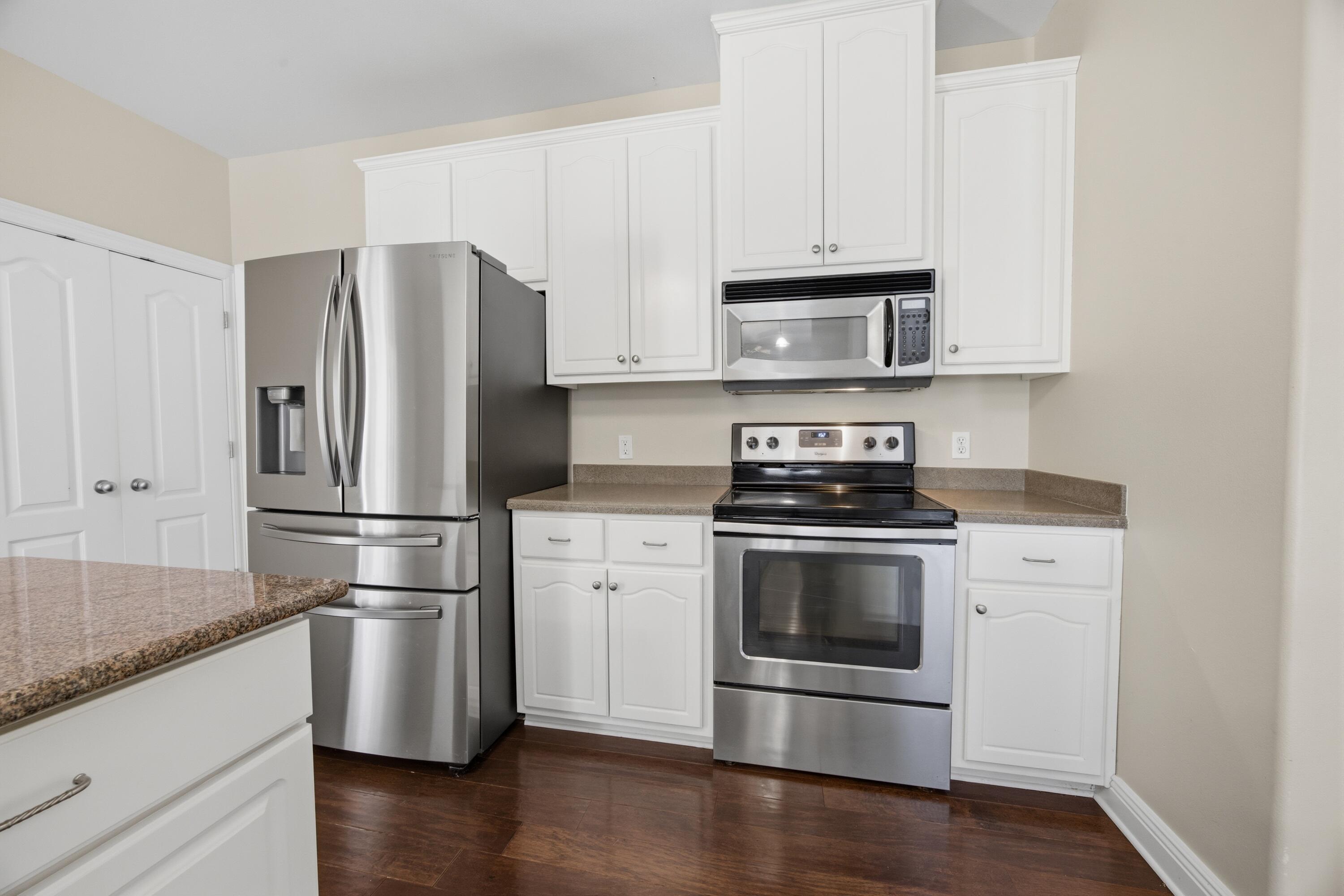 51 Tournament Lane Freeport, FL 32439 - Photo 29 of 71 a kitchen with a refrigerator stove and wooden cabinets