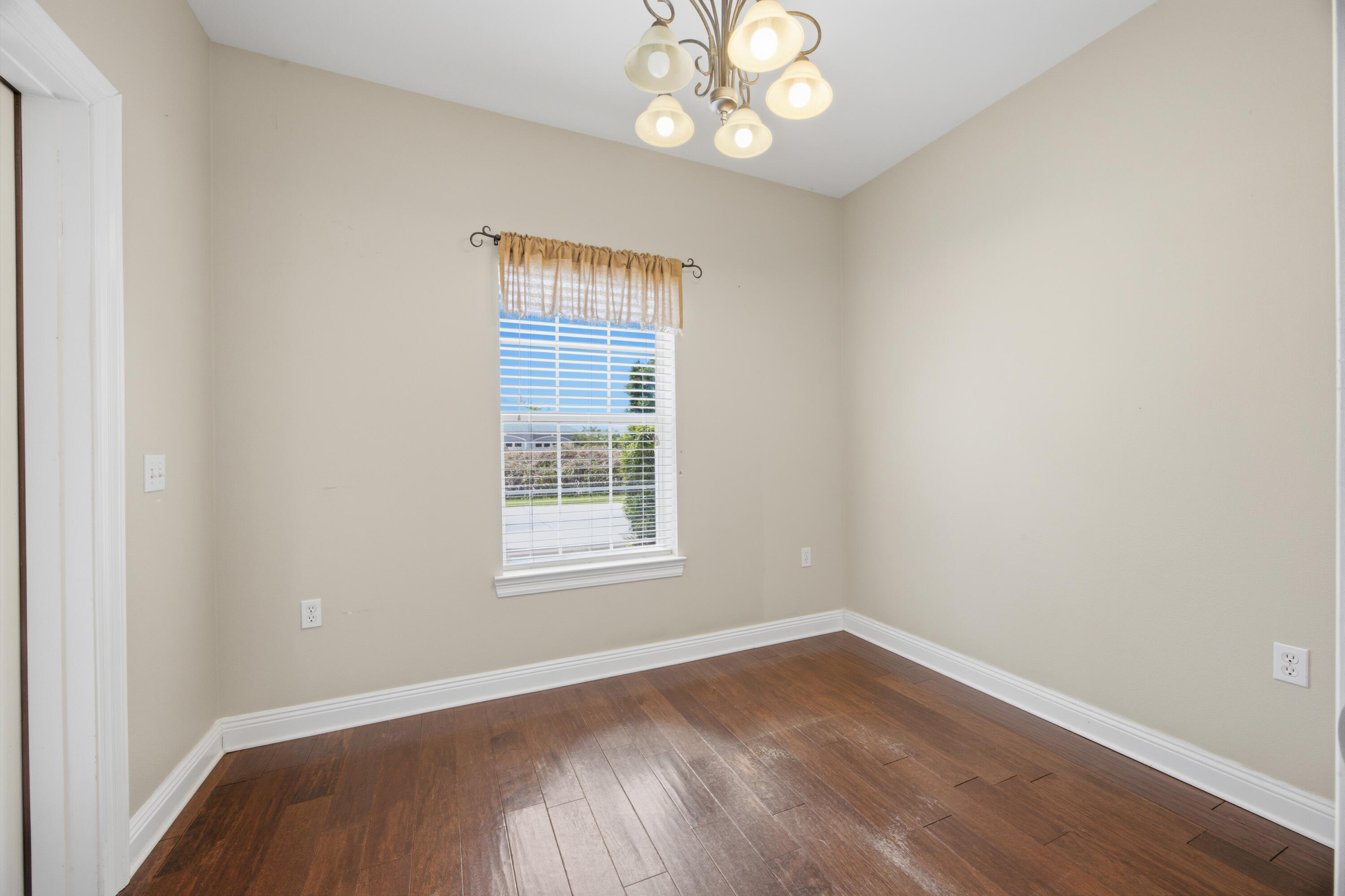 51 Tournament Lane Freeport, FL 32439 - Photo 32 of 71 an empty room with wooden floor and windows