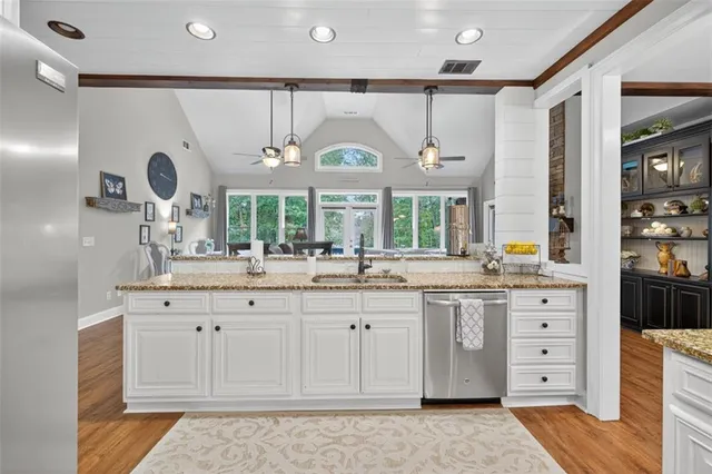 a bathroom with a granite countertop tub a double vanity sink a window and a mirror