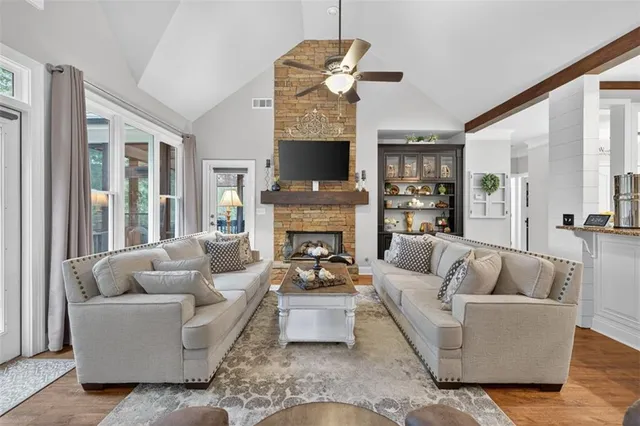a living room with furniture a flat screen tv and a fireplace