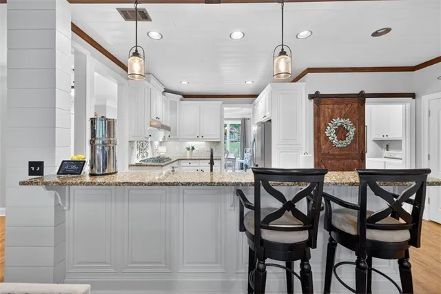 a view of a hallway with wooden floor and a chandelier
