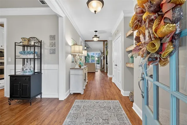a living room with furniture kitchen view and a chandelier