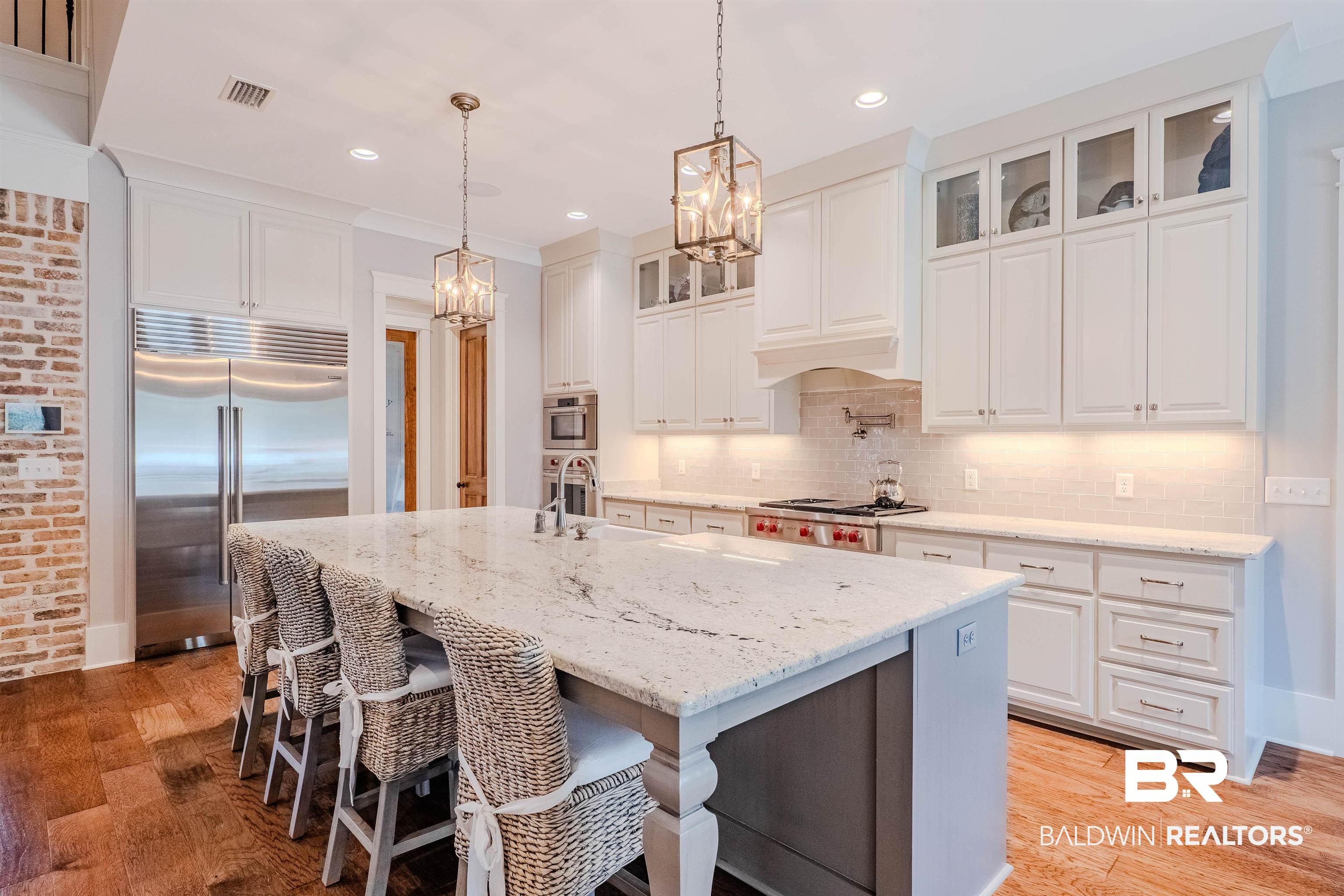 708 Manning Place Fairhope, AL 36532 - Photo 8 of 58 Kitchen with white cabinetry, an island with sink, and appliances with stainless steel finishes