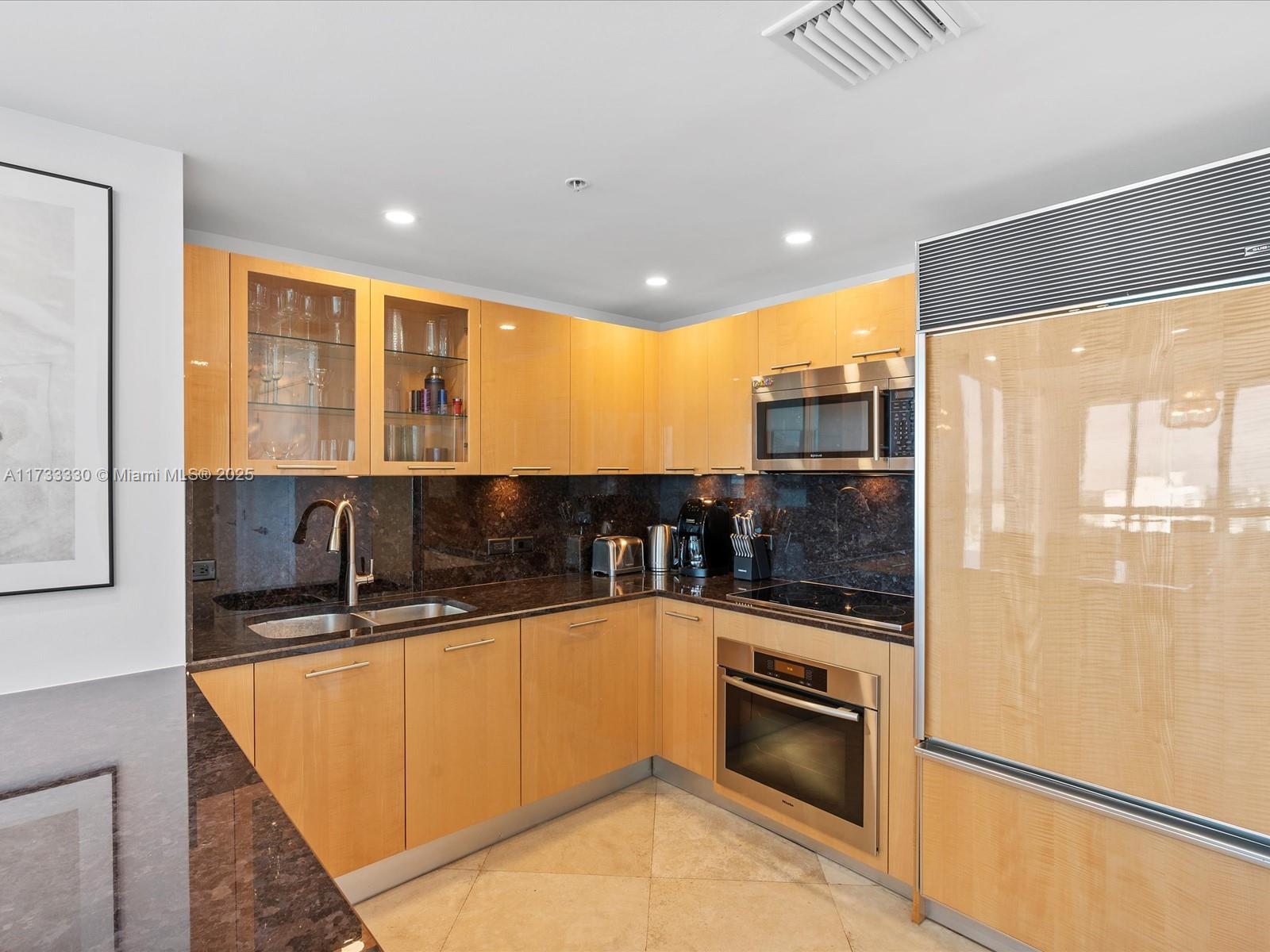 6899 Collins Avenue, Unit 1704 Miami Beach, FL 33141 - Photo 16 of 25 a kitchen with stainless steel appliances granite countertop a sink and cabinets