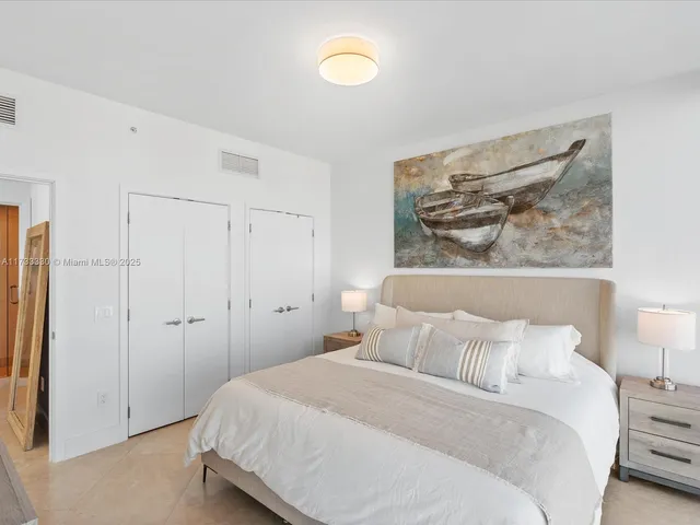 a bedroom with a bed and a painting on the wall