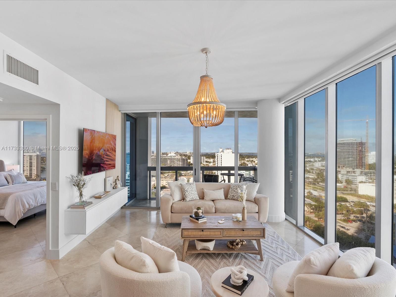 6899 Collins Avenue, Unit 1704 Miami Beach, FL 33141 - Photo 4 of 25 a living room with furniture and a flat screen tv