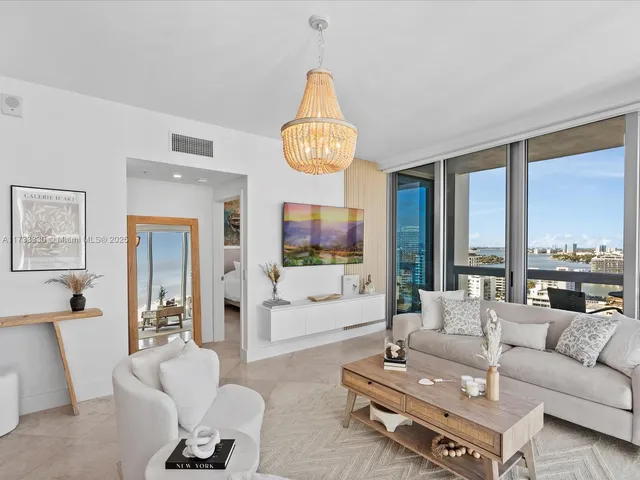 a living room with furniture a flat screen tv and a large window