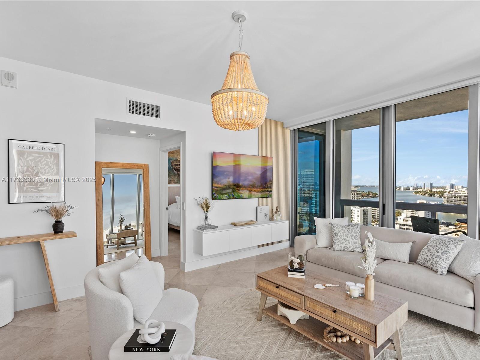 6899 Collins Avenue, Unit 1704 Miami Beach, FL 33141 - Photo 8 of 25 a living room with furniture a flat screen tv and a large window