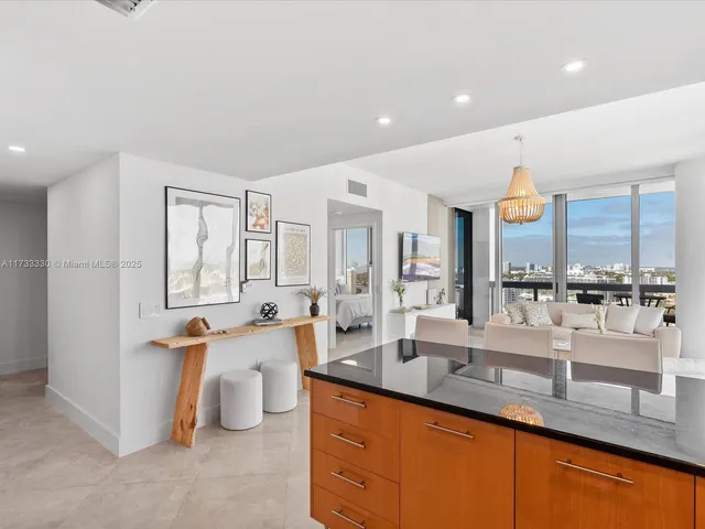 a large living room with stainless steel appliances kitchen island granite countertop a lot of counter space and a sink