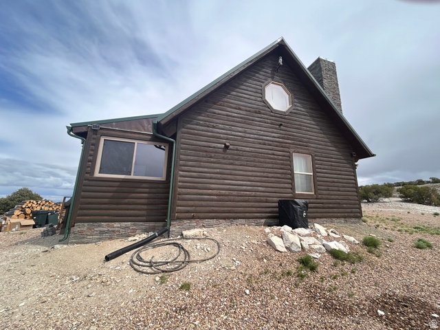 19075 West Honesty Cove Duchesne, UT 84021 - Photo 33 of 44 Log-sided exterior with a stone chimney and stone foundation detailing