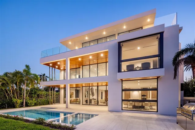 a living room with furniture floor to ceiling window and a flat screen tv