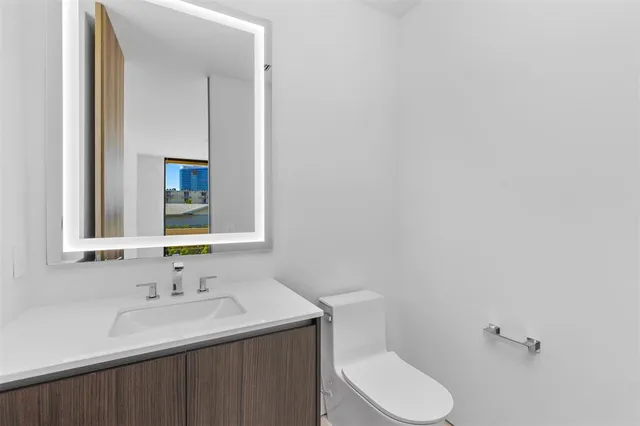 an empty room with wooden floor and windows with garden view