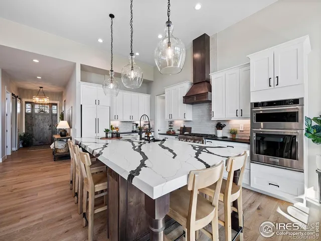 a kitchen with stainless steel appliances a refrigerator a sink a stove a microwave a counter top and cabinets