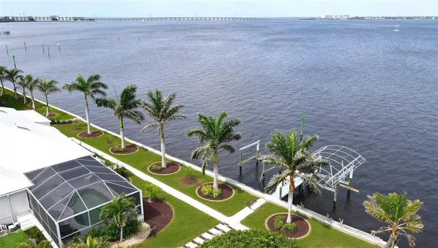 a front view of a house with a big yard and potted plants