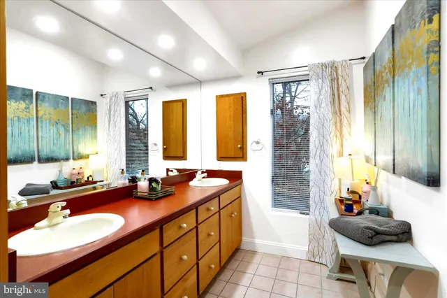 a bathroom with double vanity and a mirror