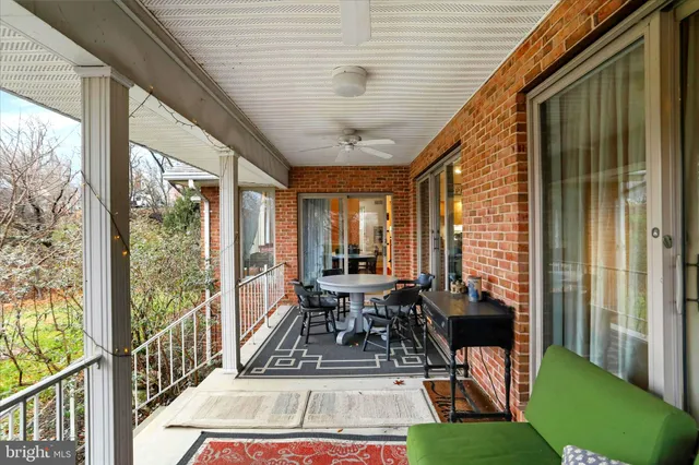 a view of a patio with couches potted plants and wooden floor