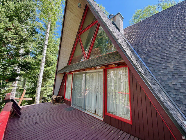 12498 East Wilderness Road Brighton, UT 84121 - Photo 21 of 40 A-frame exterior featuring a prominent red-framed window wall, expansive wood deck, and a shingle roof