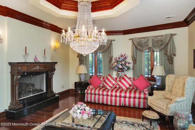 a living room with furniture a chandelier and a fireplace