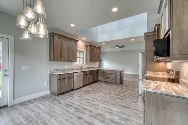 a kitchen with stainless steel appliances kitchen island granite countertop a sink and cabinets
