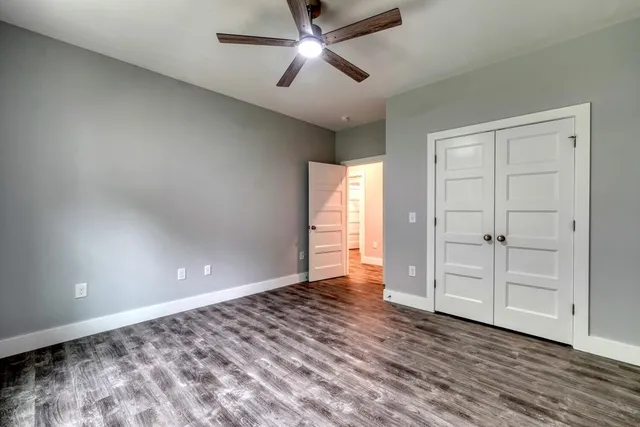 an empty room with closet and windows