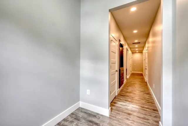 a view of a hallway with wooden floor