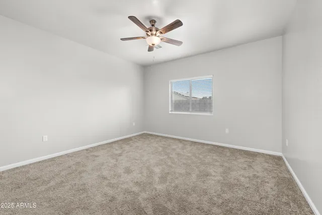 an empty room with closet and ceiling fan