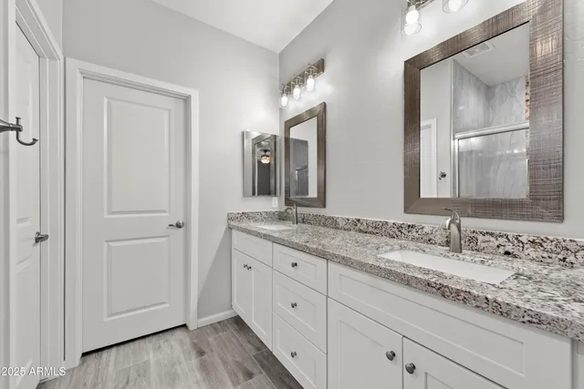 a bathroom with a granite countertop sink and a mirror