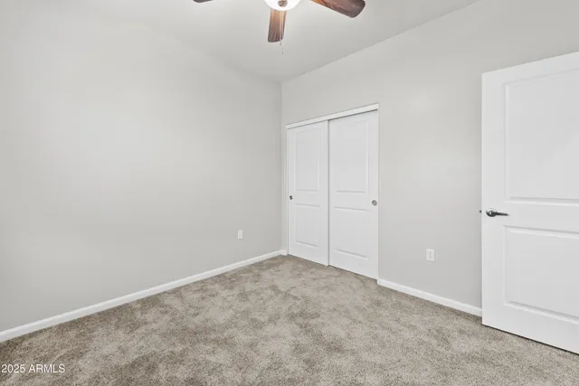 an empty room with a chandelier fan