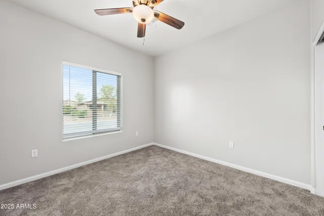 an empty room with a window and a ceiling fan