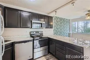 a kitchen with stainless steel appliances granite countertop a sink stove and microwave