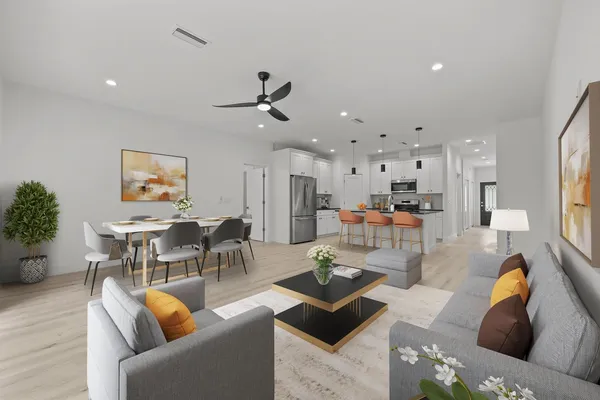 a living room with furniture kitchen view and a chandelier