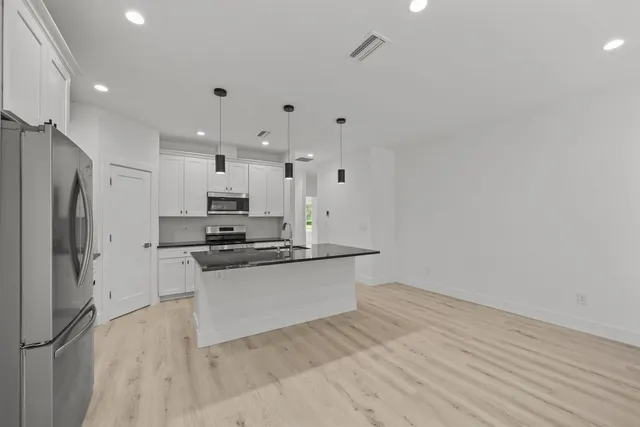 a kitchen with stainless steel appliances a refrigerator and a stove