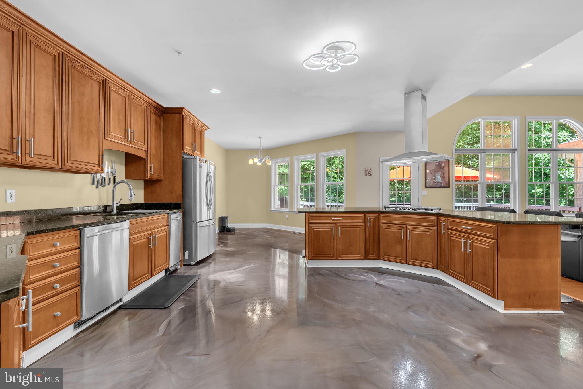 13716 Molly Berry Road Brandywine, MD 20613 - Photo 13 of 75 a large kitchen with stainless steel appliances granite countertop a stove a sink dishwasher a microwave oven with cabinets and wooden floor