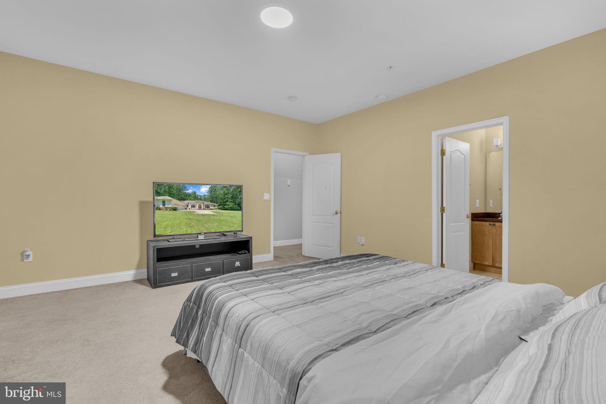 13716 Molly Berry Road Brandywine, MD 20613 - Photo 22 of 75 a bedroom with a bed and a flat screen tv