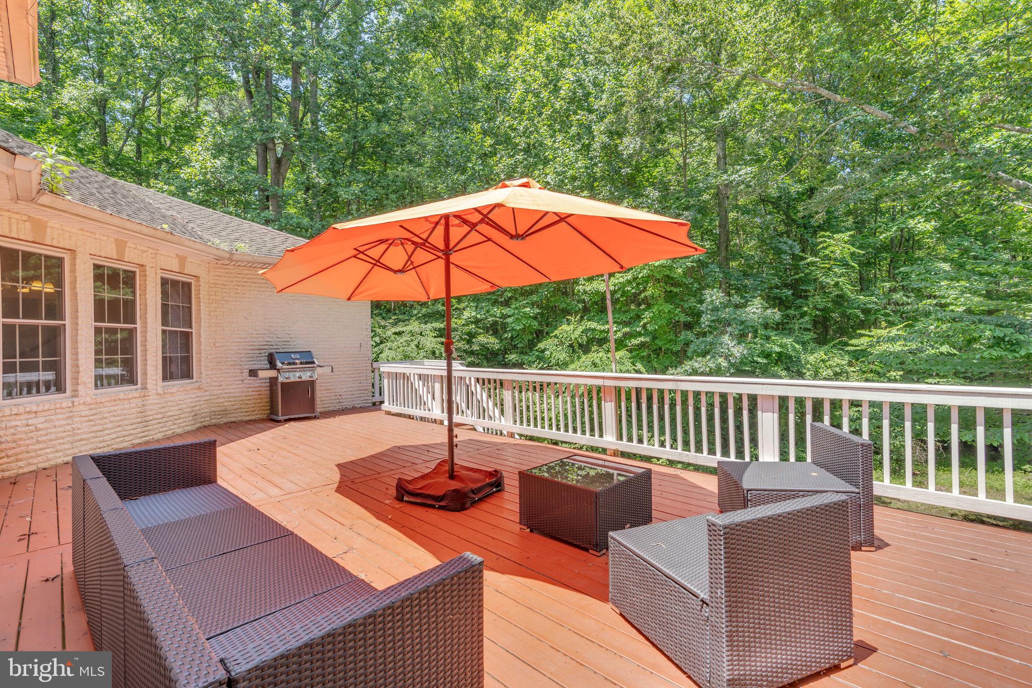 13716 Molly Berry Road Brandywine, MD 20613 - Photo 57 of 75 a view of a patio with a table chairs and a umbrella