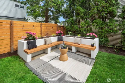 a view of a patio with table and chairs potted plants and a large tree