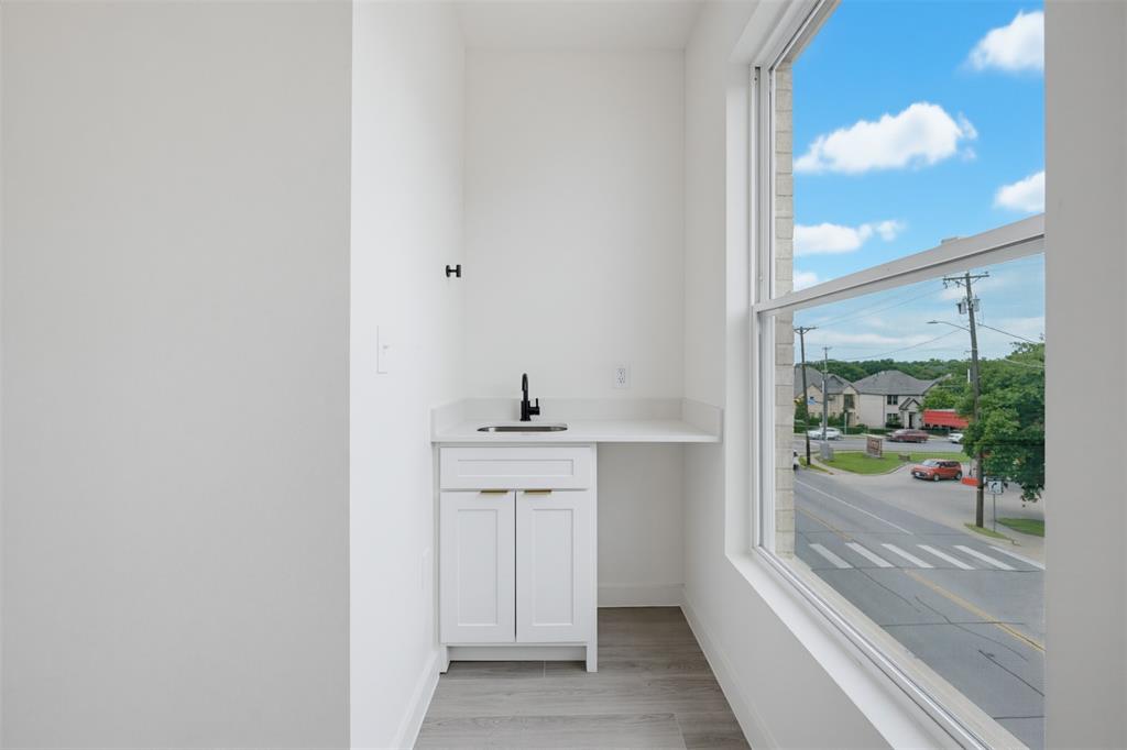 516 South O Connor Road Irving, TX 75060 - Photo 14 of 23 Bright space featuring a white vanity cabinet with gold-finish pulls, a light countertop, and a black faucet