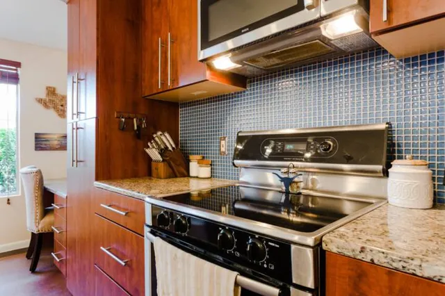 a kitchen with granite countertop stainless steel appliances stove and cabinets