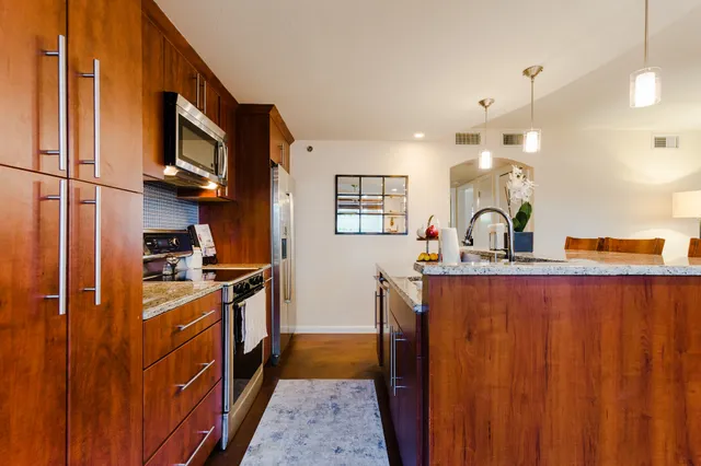 a kitchen with stainless steel appliances granite countertop a sink stove and refrigerator