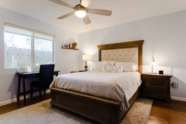 a bedroom with a bed lamps and a large window