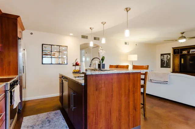 a view of a kitchen with kitchen island a sink stainless steel appliances and cabinets