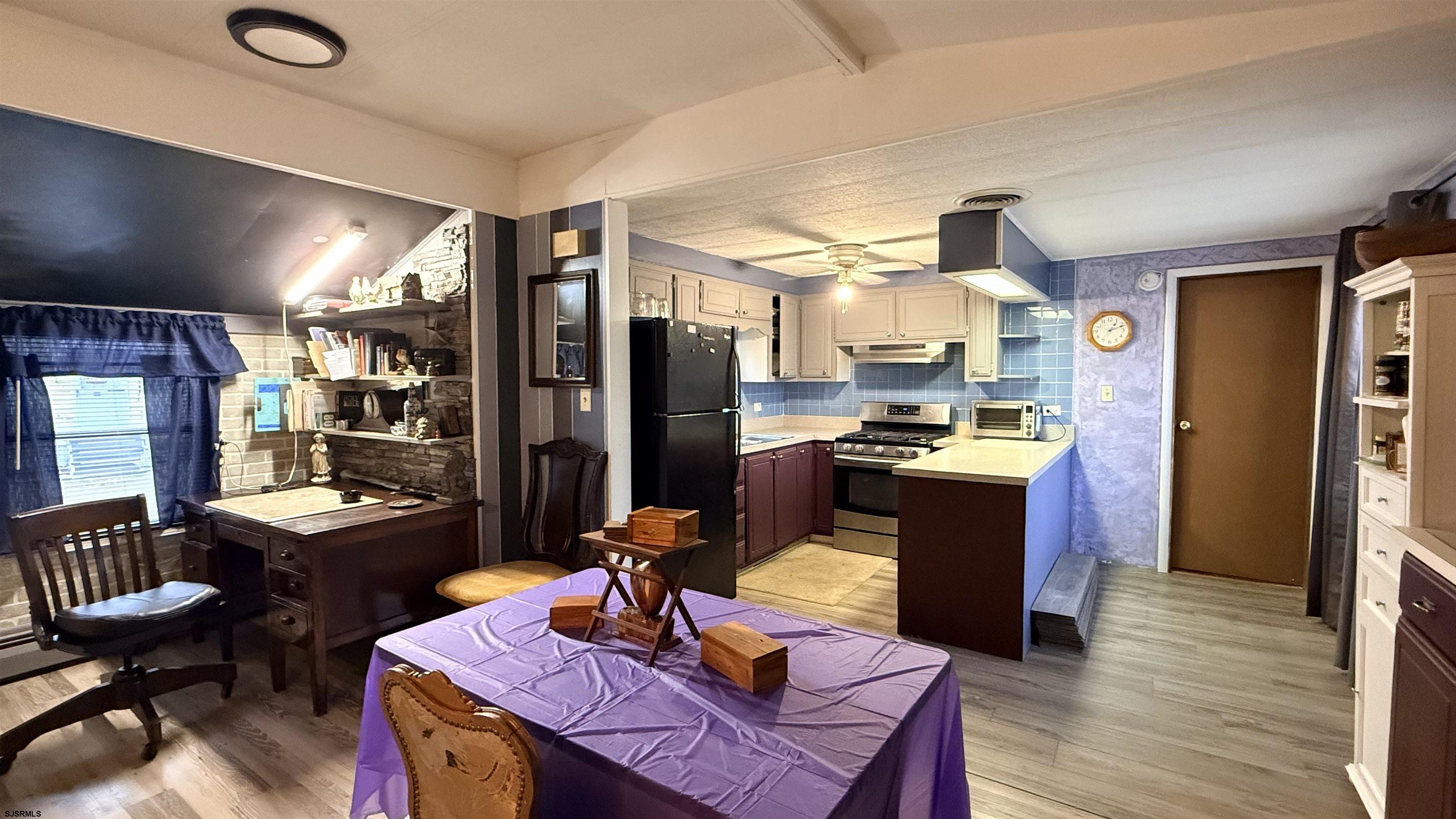 101 Country Lane Buena, NJ 08310 - Photo 7 of 25 a kitchen with stainless steel appliances kitchen island granite countertop a refrigerator a stove and a sink with wooden floor