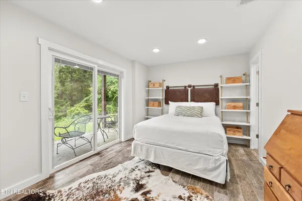 a view of a hallway with bathroom and wooden floor