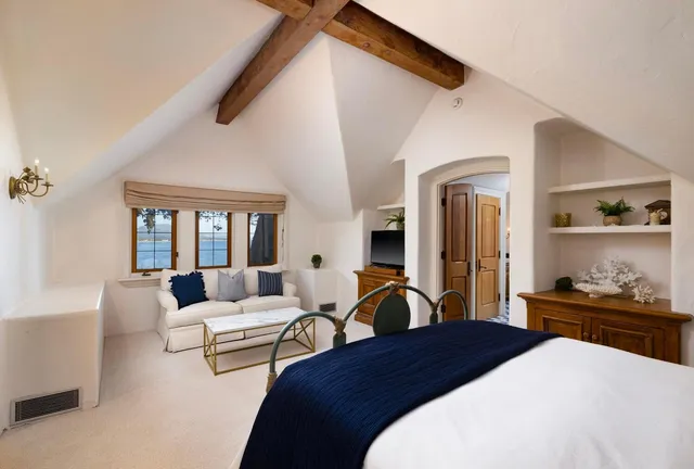 a bedroom with furniture and a large window