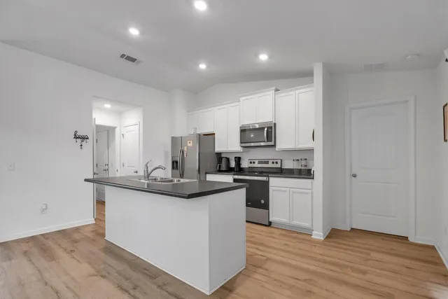 a kitchen with stainless steel appliances granite countertop a sink and cabinets