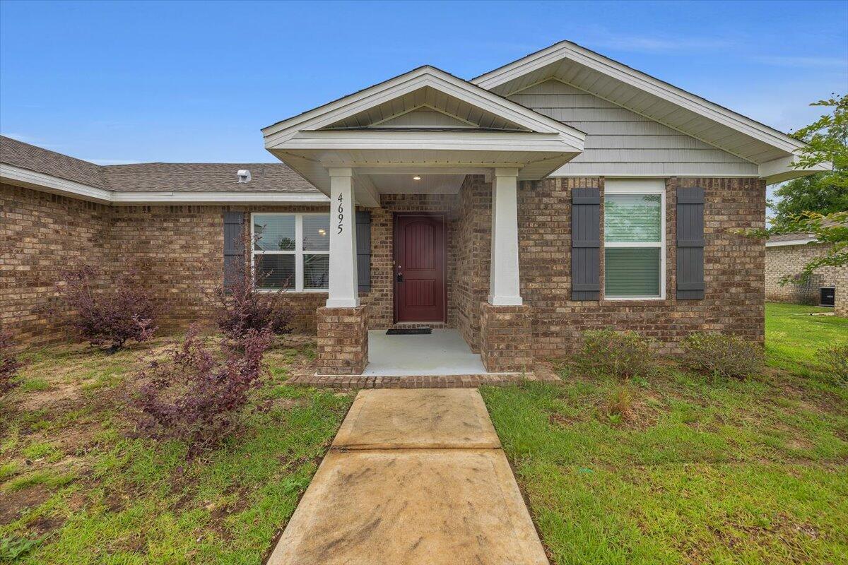 4695 Perception Circle Milton, FL 32570 - Photo 2 of 30 a view of a brick house with many windows next to a yard