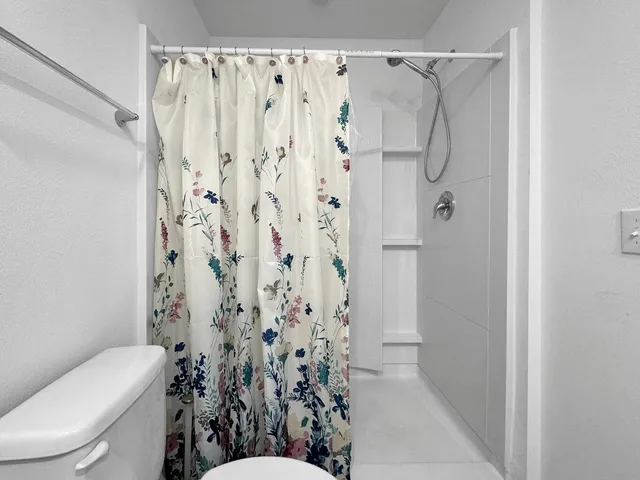 a bathroom with a toilet and shower curtain