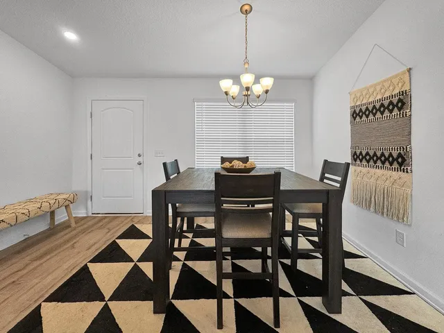 a view of a dining room with a table and chairs
