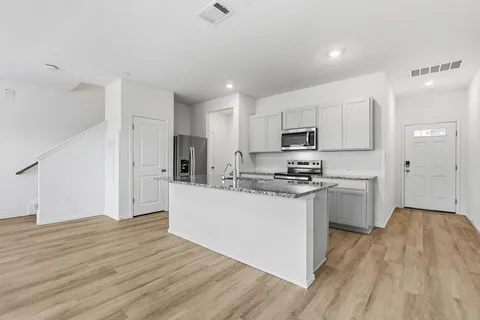 a kitchen with white cabinets and sink
